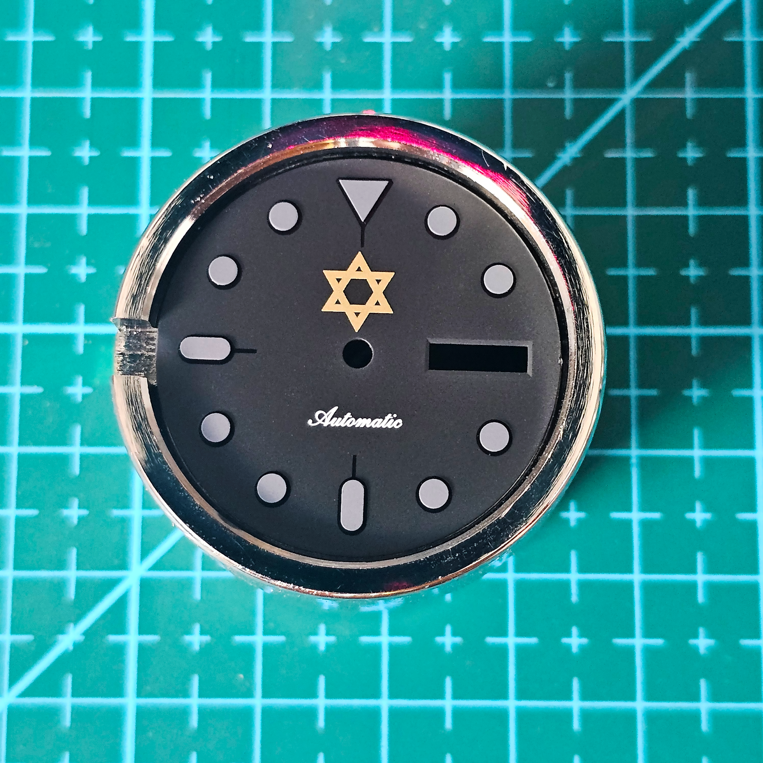 custom engraved watch dial on movement holder after laser engraving process