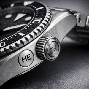 Side view of a dive watch case showing a helium escape valve used for saturation diving