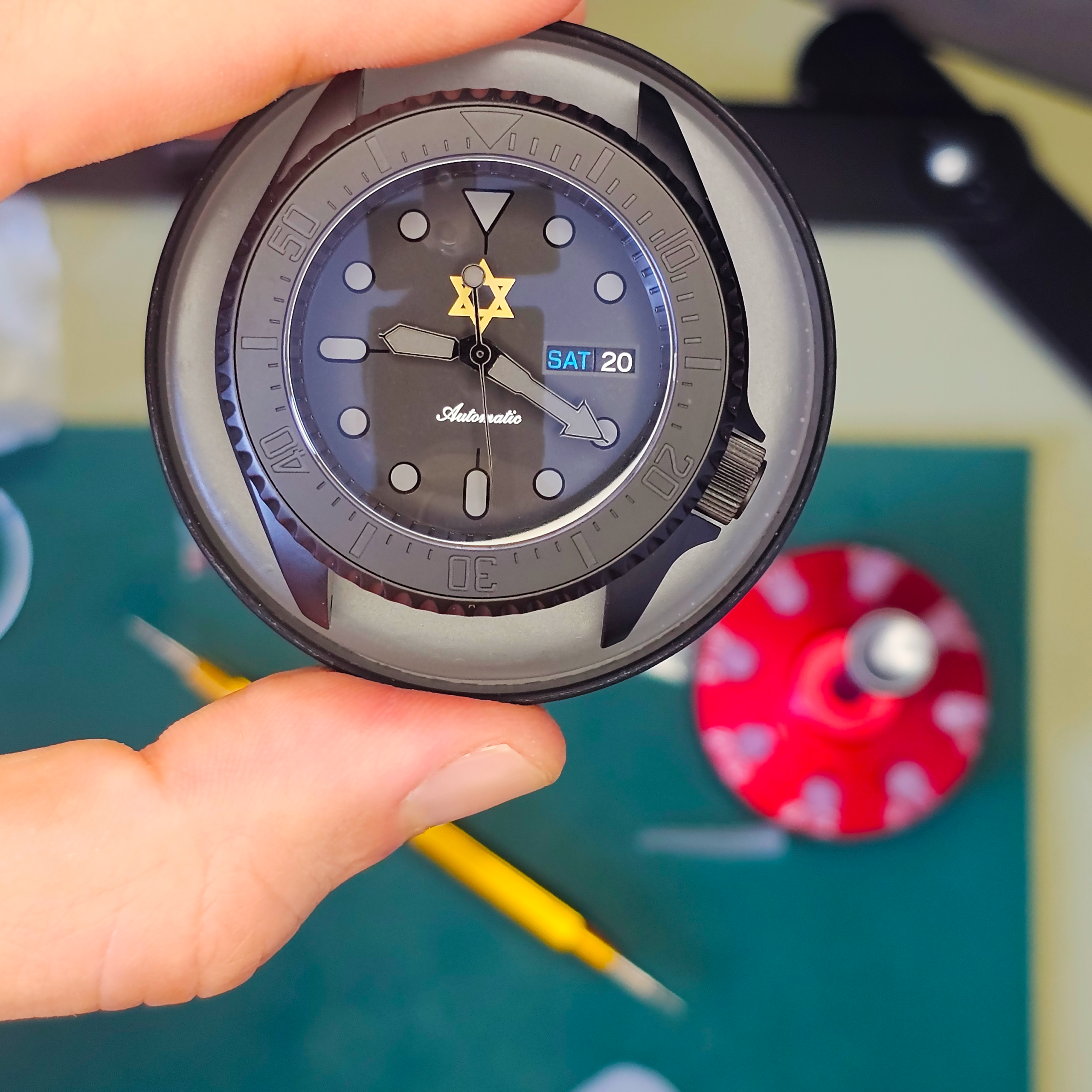 hand holding a nearly finished Seiko mod watch build without strap attached