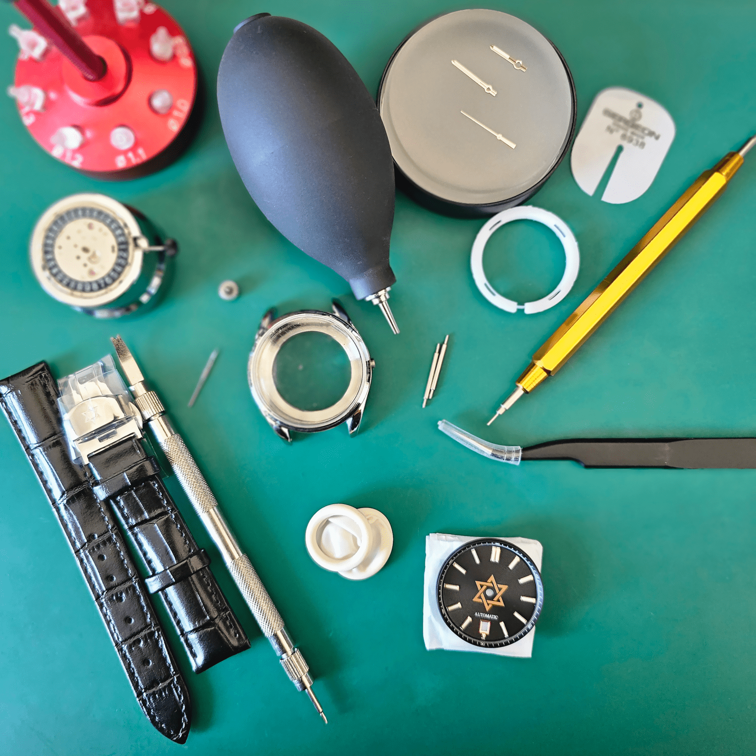 Seiko modding tools and watch parts arranged on green work mat during assembly