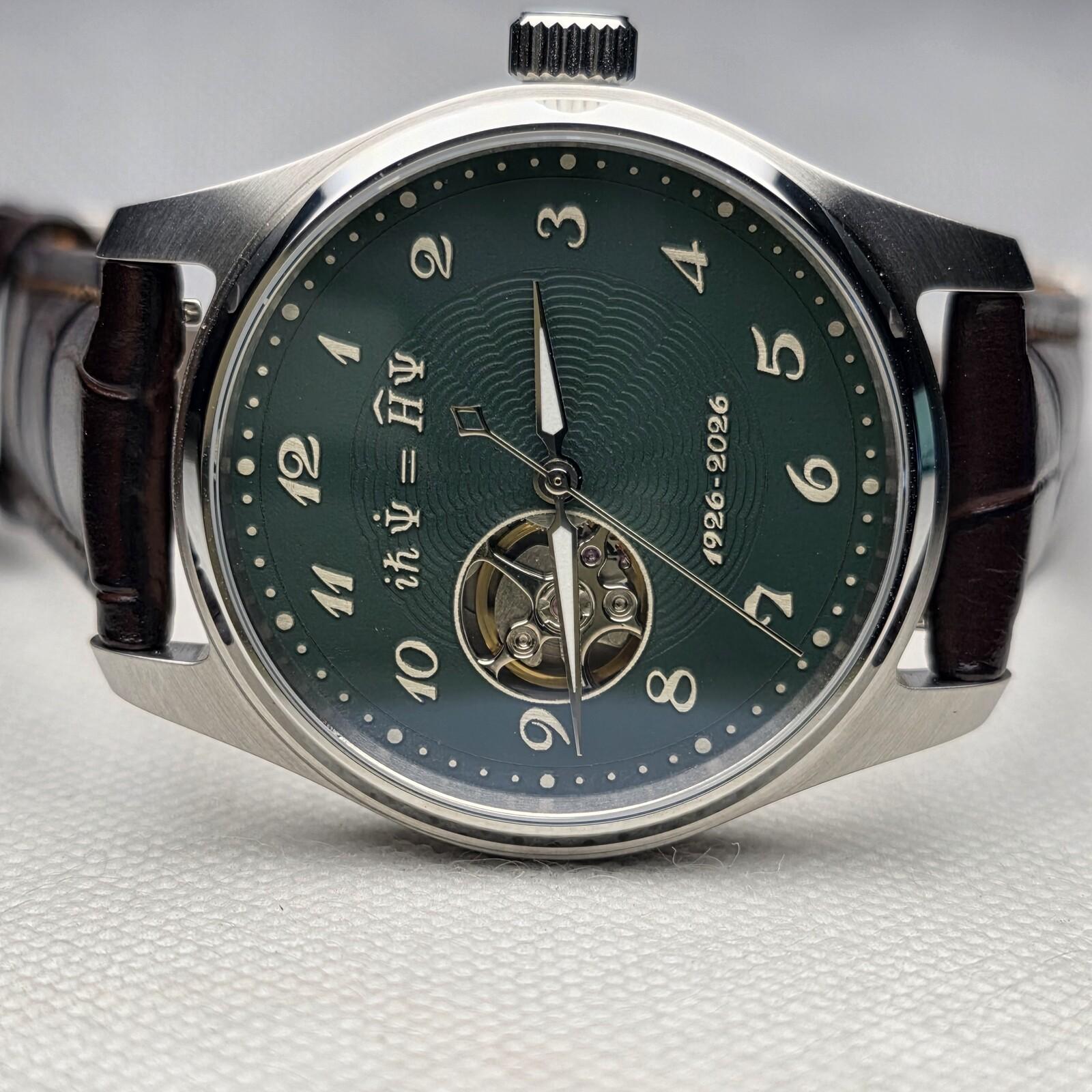 Green mechanical watch dial carrying the Schrodinger equation and an open-heart display