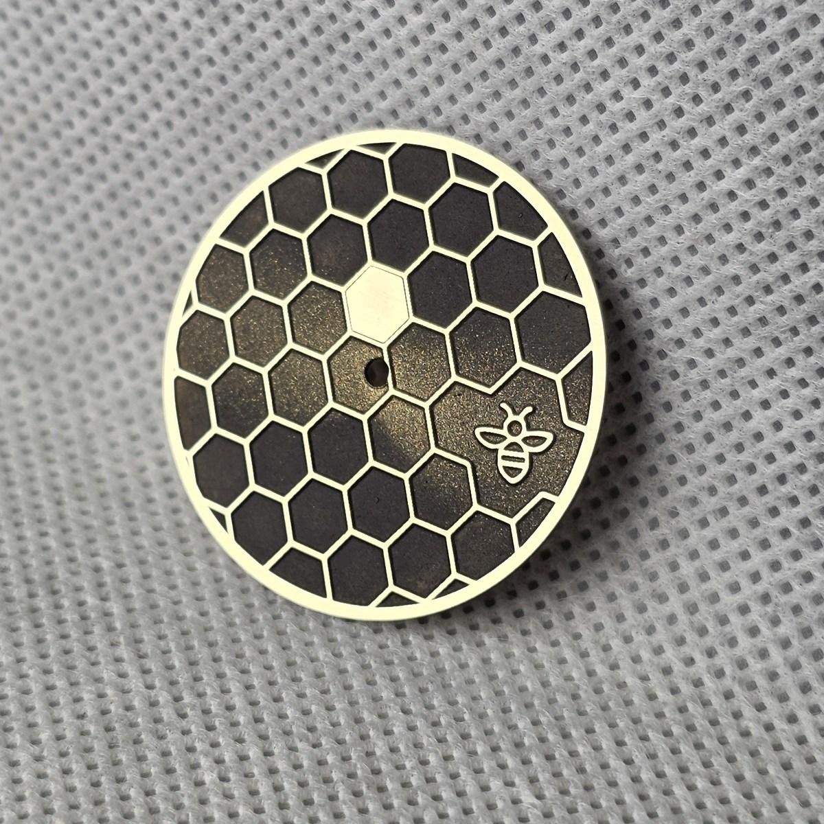 An angled view of the Honeycomb dial showing the raised outlines and small bee